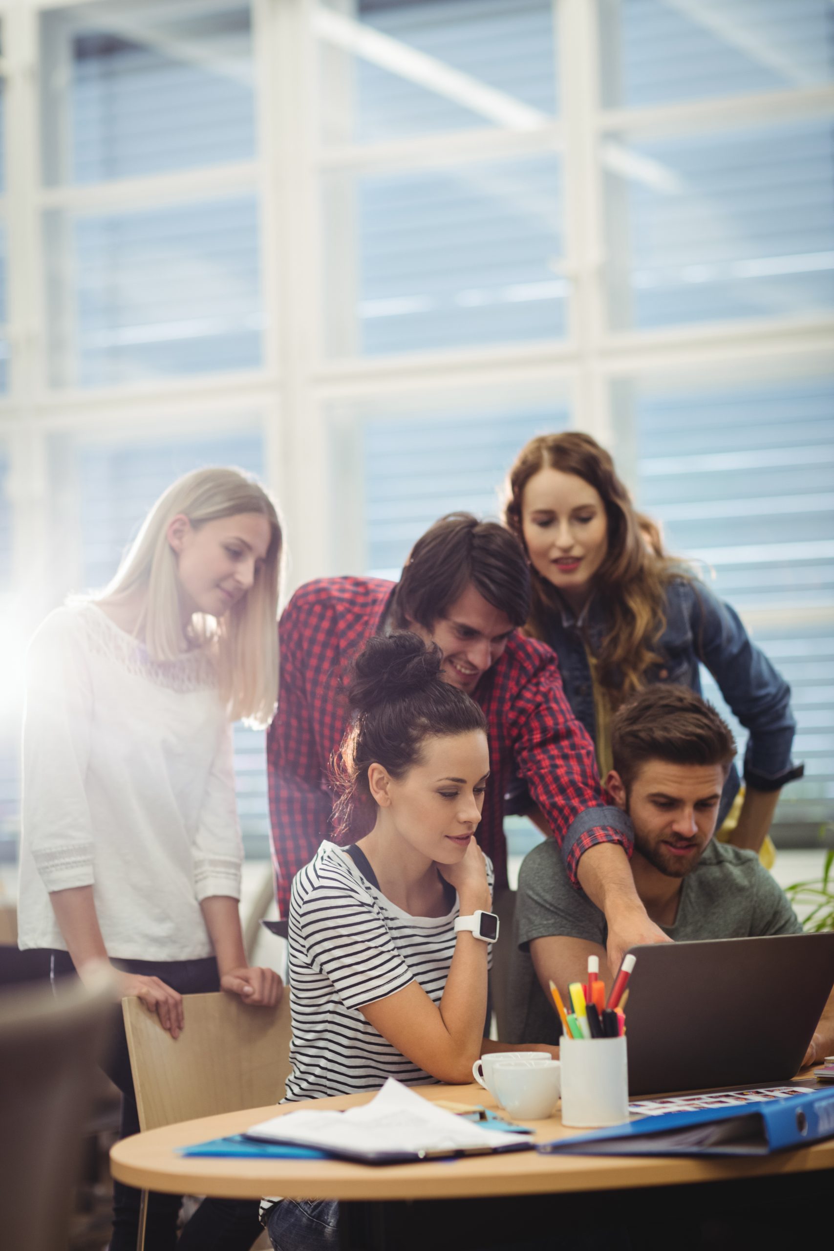 Group of business executives discussing over laptop at their desk